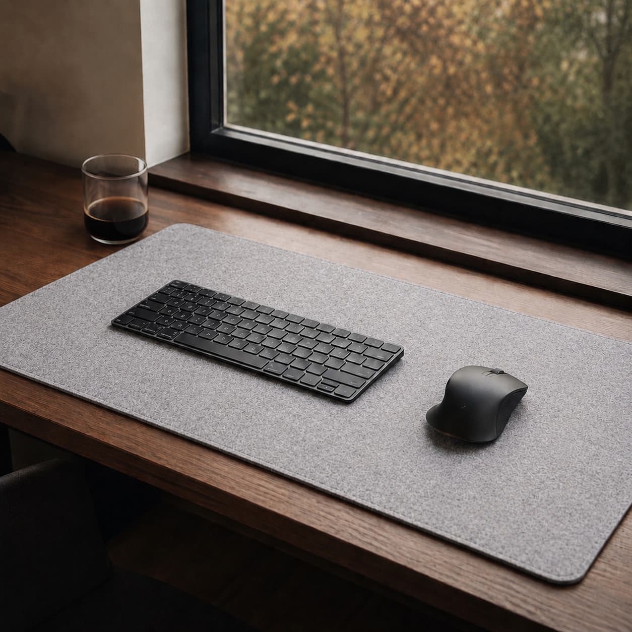 Aovela felt and cork double-sided desk mat on a warm wood home-office desk