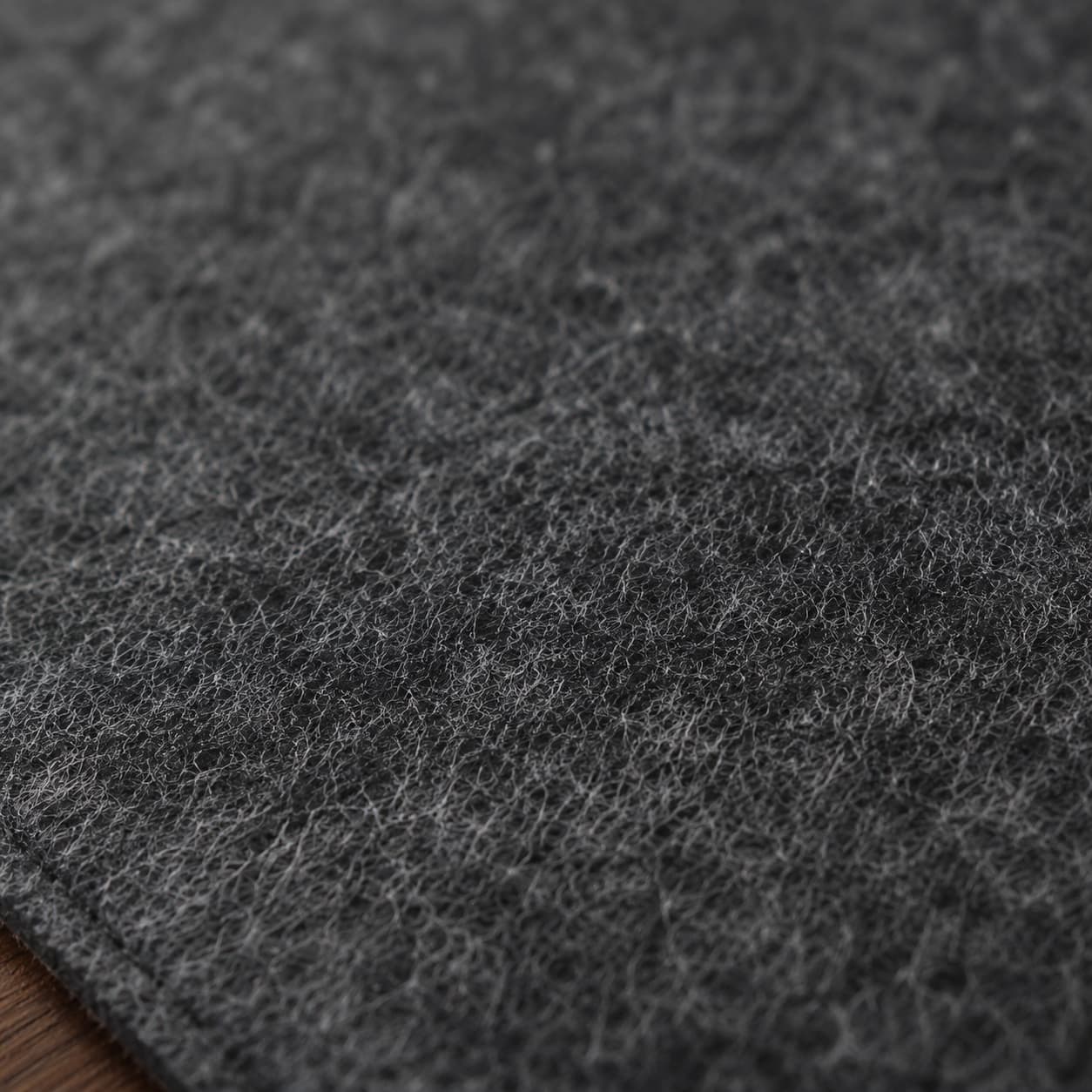 Aovela felt and cork double-sided desk mat on a warm wood home-office desk